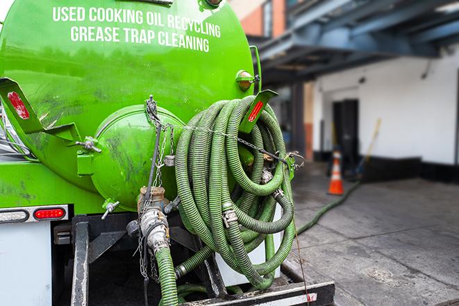 a technician pumping a grease trap in a commercial building in Lake Orion, MI